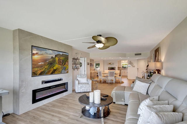 living room featuring light wood-type flooring and ceiling fan