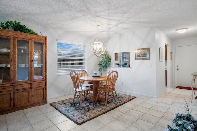 dining area with a textured ceiling, a chandelier, and light tile patterned floors