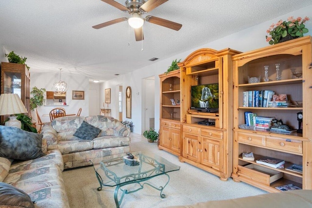 living room with light carpet, a textured ceiling, and ceiling fan with notable chandelier