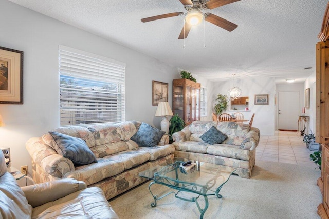 living room with ceiling fan and a textured ceiling