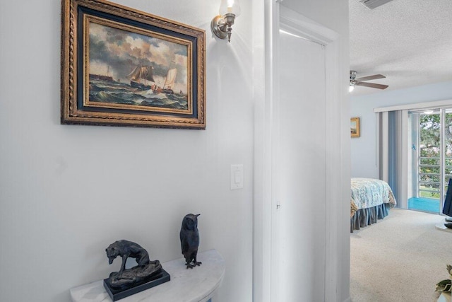 corridor featuring a textured ceiling and carpet