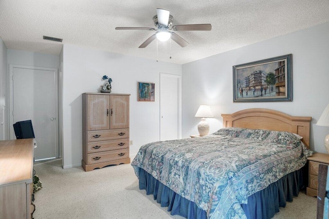 bedroom with ceiling fan and a textured ceiling