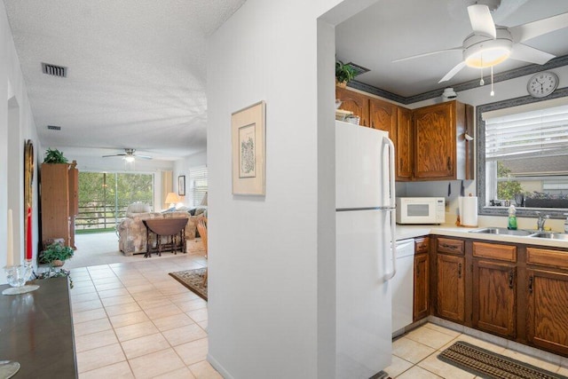 kitchen with white appliances, light tile patterned floors, sink, and plenty of natural light