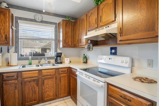 kitchen featuring light tile patterned floors, white electric stove, and sink