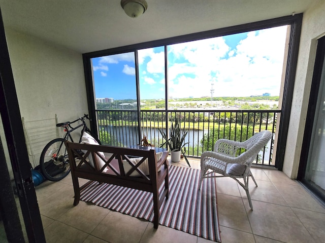 sunroom featuring a water view