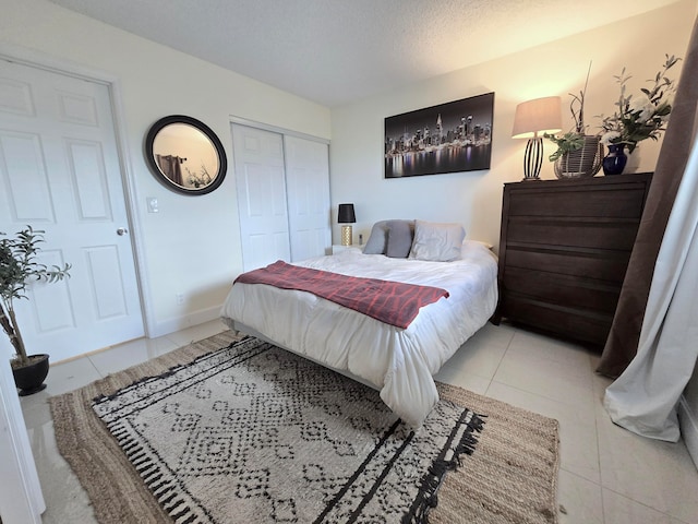 tiled bedroom featuring a closet and a textured ceiling