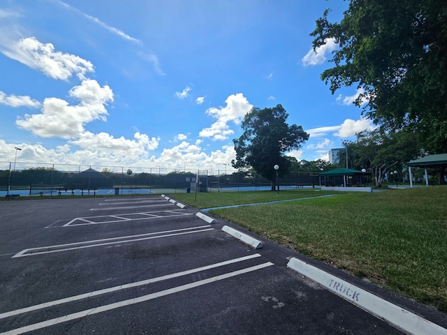 view of parking / parking lot featuring a lawn