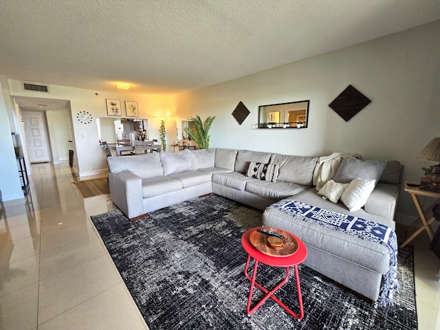 living room with a textured ceiling and tile patterned floors