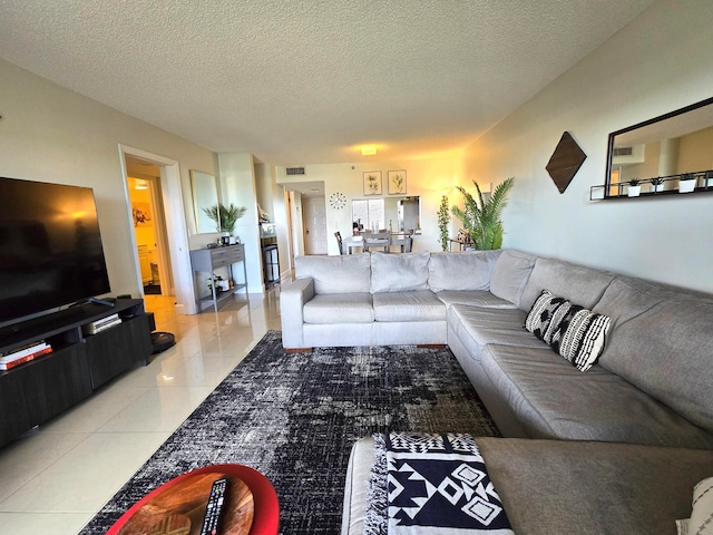 living room with a textured ceiling and light tile patterned flooring