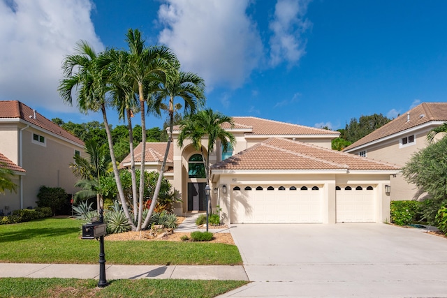 mediterranean / spanish-style house featuring a front lawn and a garage