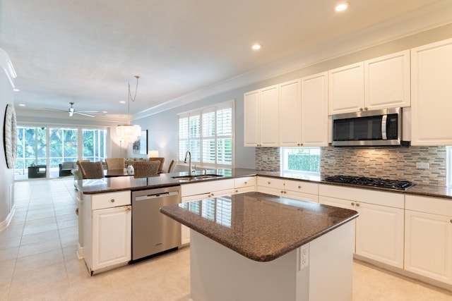 kitchen featuring appliances with stainless steel finishes, sink, a center island, kitchen peninsula, and ceiling fan