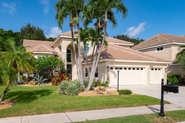 mediterranean / spanish-style home featuring a front yard and a garage