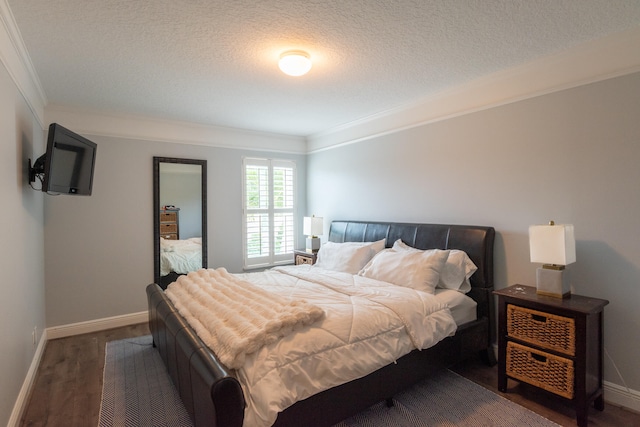 bedroom featuring a textured ceiling, crown molding, and dark hardwood / wood-style floors