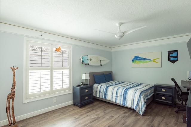 bedroom featuring dark wood-type flooring, ceiling fan, and a textured ceiling