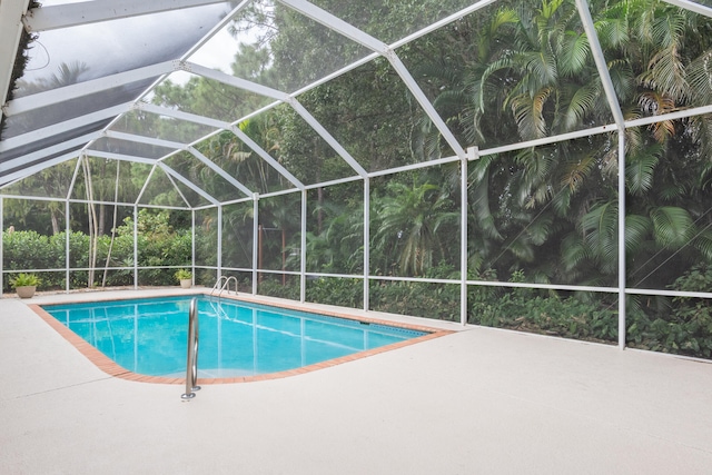 view of swimming pool featuring a patio area and glass enclosure