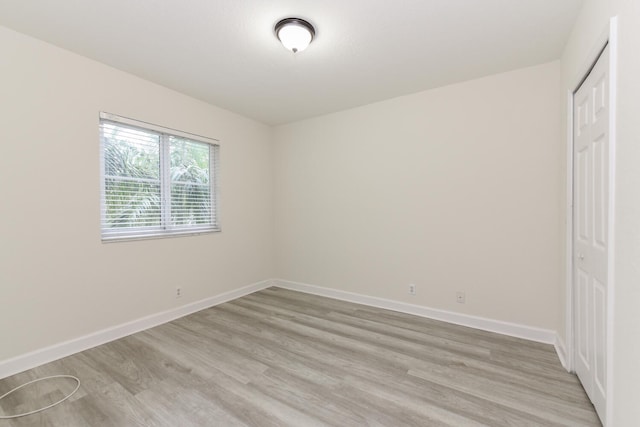 unfurnished bedroom featuring a closet and light wood-type flooring