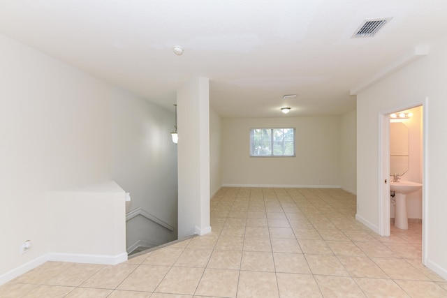 basement with sink and light tile patterned floors