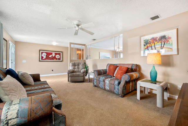 living room featuring ceiling fan, a textured ceiling, and carpet flooring