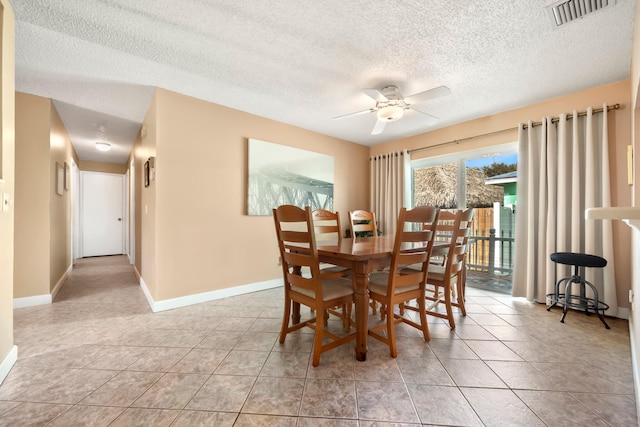 dining area with a textured ceiling, ceiling fan, and light tile patterned flooring