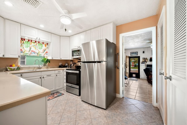 kitchen with white cabinetry, stainless steel appliances, and light tile patterned flooring