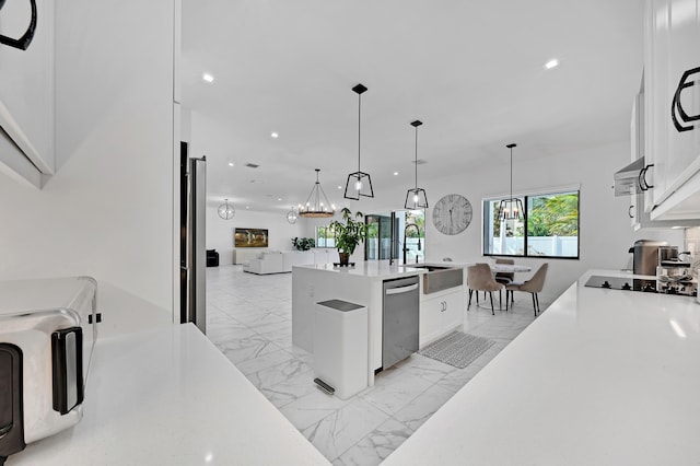 kitchen featuring white cabinets, sink, pendant lighting, and dishwasher