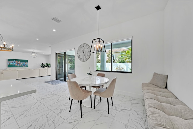 dining area featuring plenty of natural light and an inviting chandelier