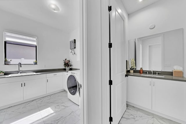 clothes washing area featuring cabinets, washer / dryer, and sink