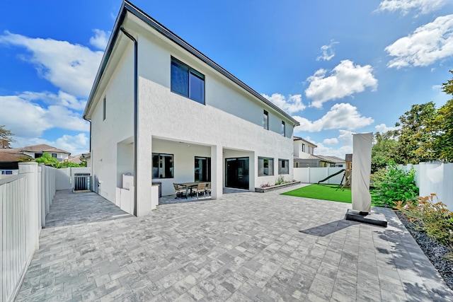 back of property featuring a patio and a yard