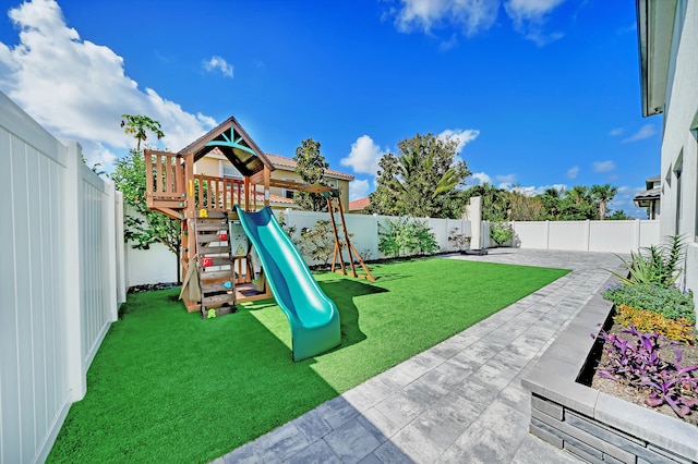 view of playground with a patio and a yard