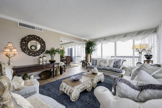 tiled living room with crown molding, visible vents, and a textured ceiling