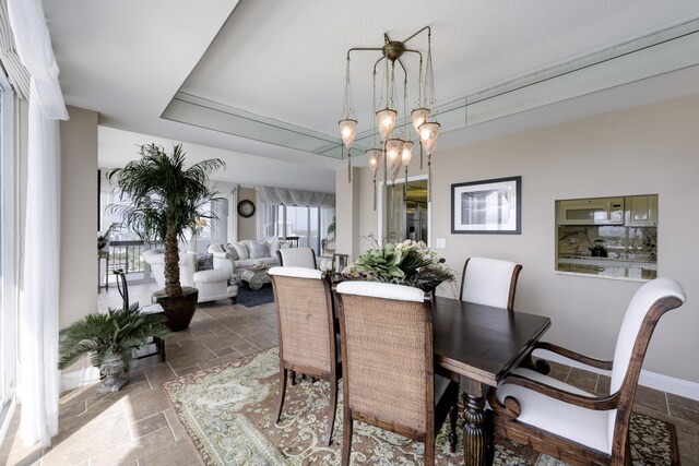 dining room with a chandelier and stone tile flooring