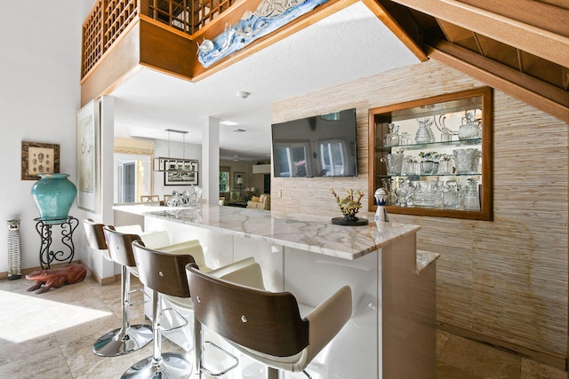 kitchen featuring kitchen peninsula, hanging light fixtures, and a breakfast bar area