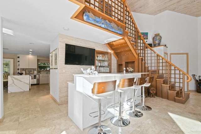 interior space with dishwasher, white cabinets, a kitchen breakfast bar, and kitchen peninsula