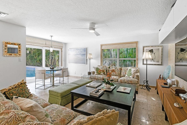 living room featuring a textured ceiling and ceiling fan