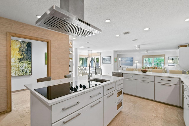 kitchen with white cabinets, a center island with sink, a textured ceiling, sink, and ventilation hood