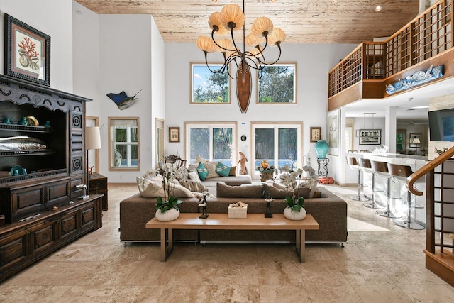 living room with a towering ceiling, a chandelier, and wooden ceiling