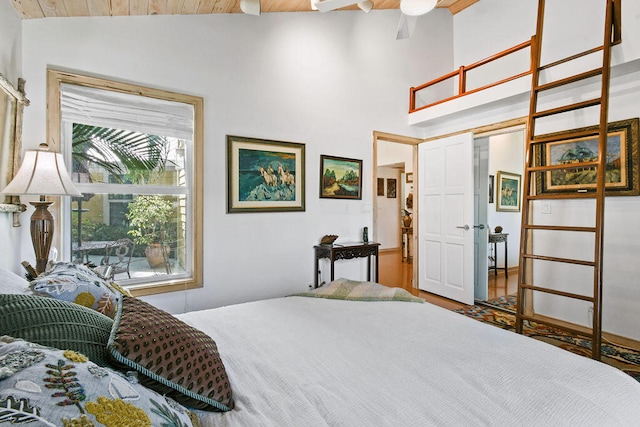 bedroom with vaulted ceiling with beams, hardwood / wood-style floors, wooden ceiling, and ceiling fan