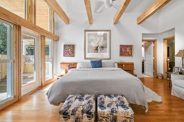 bedroom featuring beam ceiling, light hardwood / wood-style flooring, multiple windows, and ceiling fan