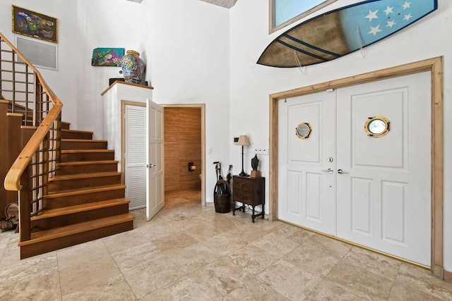 2388 Palm Harbor Dr, Palm Beach Gardens, FL 33410 - entryway with stairs, a high ceiling, stone finish floors, and baseboards