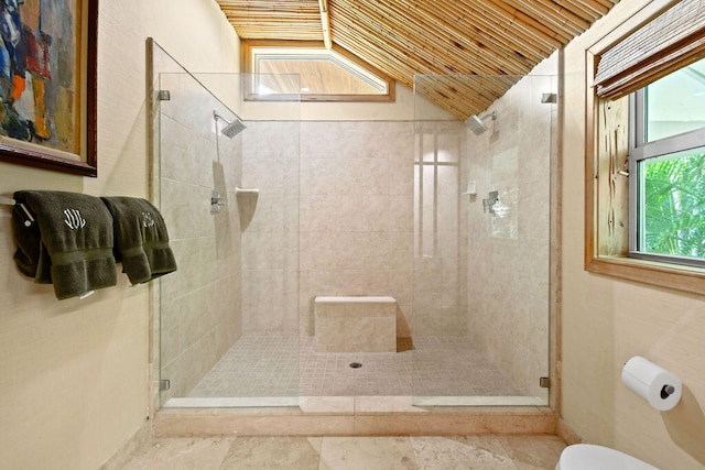 bathroom with toilet, a shower with shower door, and vaulted ceiling