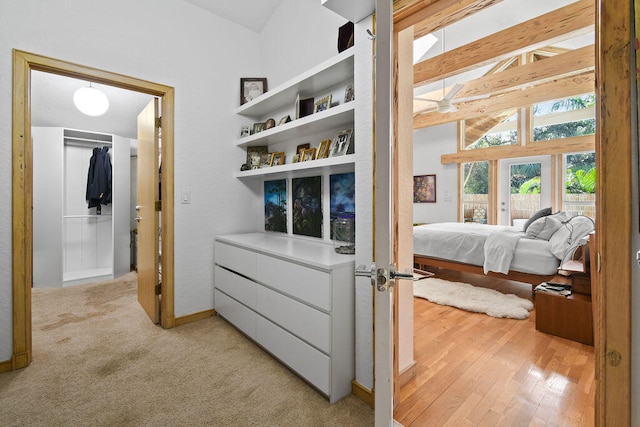 bedroom featuring lofted ceiling with beams and light hardwood / wood-style flooring