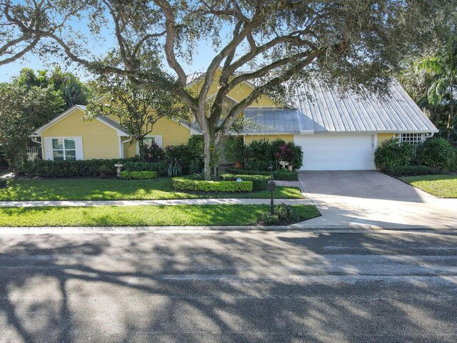 2388 Palm Harbor Dr, Palm Beach Gardens, FL 33410 - view of front of house featuring driveway and a front yard