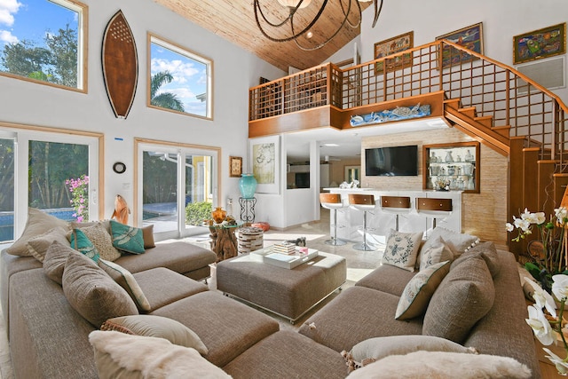 living room with a high ceiling, a healthy amount of sunlight, and wooden ceiling