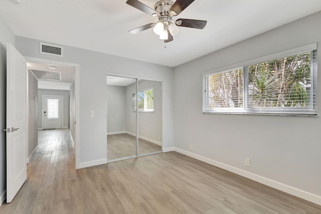 unfurnished bedroom with ceiling fan, a closet, and light wood-type flooring