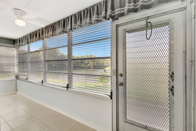 doorway to outside featuring ceiling fan and tile patterned floors