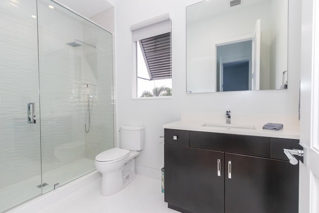 bathroom with vanity, a shower with shower door, toilet, and tile patterned floors