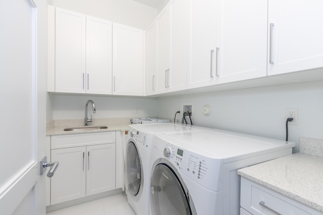 laundry room with sink, washer and clothes dryer, light tile patterned floors, and cabinets