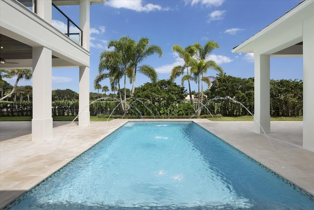 view of pool with a patio, ceiling fan, and pool water feature