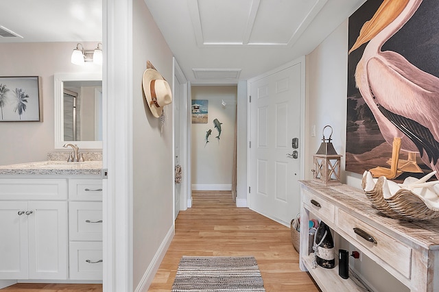 mudroom with light hardwood / wood-style floors and sink