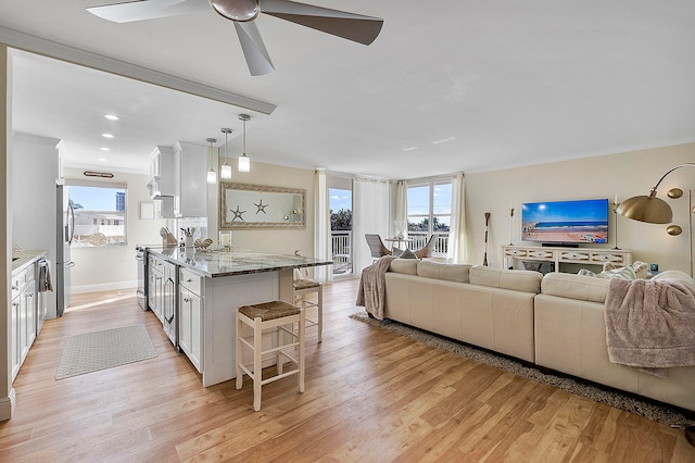 living room with crown molding, light hardwood / wood-style flooring, a wealth of natural light, and ceiling fan